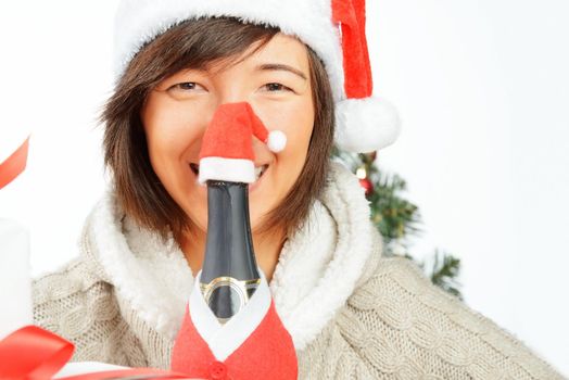 Bottle of champagne in front of a woman in santa hat