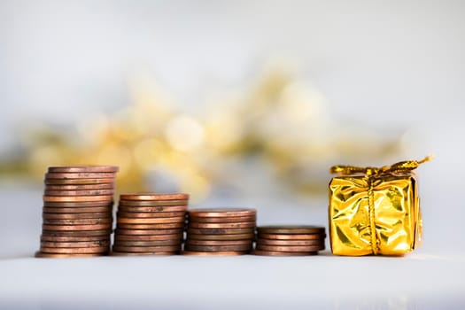Coin climbing stairs with Christmas Holiday present, sparkling and shiny background, Finance,saving concept stacks of coins copy space