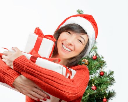 Happy woman is hugging gift box on the background of Christmas tree