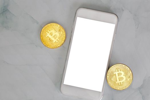 golden bitcoin lies on a smartphone on marble background top view with copy space, cryptocurrency or digital money concept , blacnk mobile phone modern design