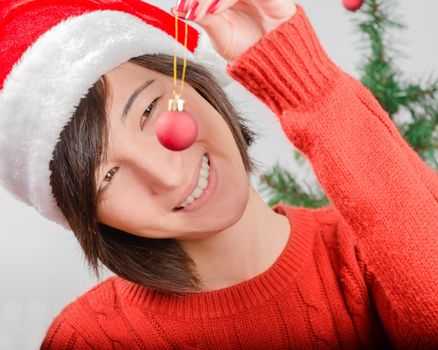 Happy young woman looking for a toy for Christmas tree