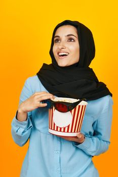 woman in black hijab with popcorn hands studio lifestyle. High quality photo