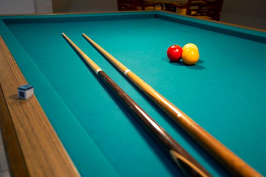 A green cloth billiards or pool table red,yellow and white ball,hobby and sport with copy space closeup