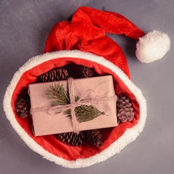 Gift box with cones in santa hat