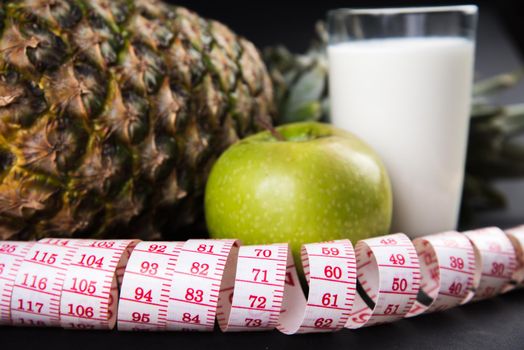 Fruits and glass of kefir with a measuring tape, close-up