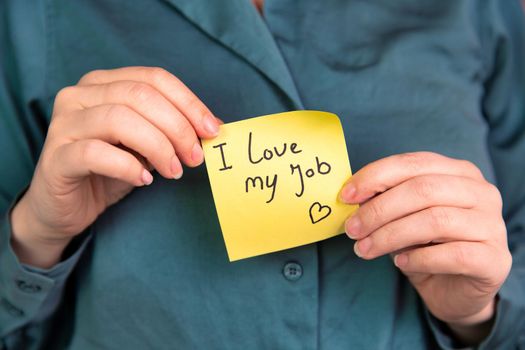 I Love My Job Note in hand, business woman or man with yellow sticky note with positive achievement, business,goals,education,people concept close up