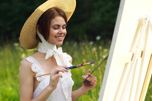 Woman in white dress artist paints on nature palette creative. High quality photo