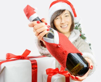 Happy woman in santa hat is giving a bottle of champagne