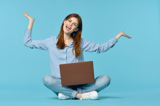 woman with laptop learning internet online education blue background. High quality photo