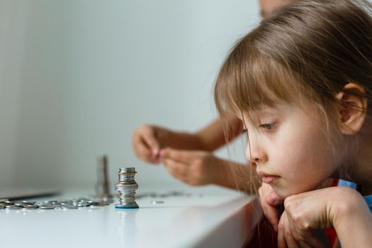 portrait of little girls sitting at table and calculating money