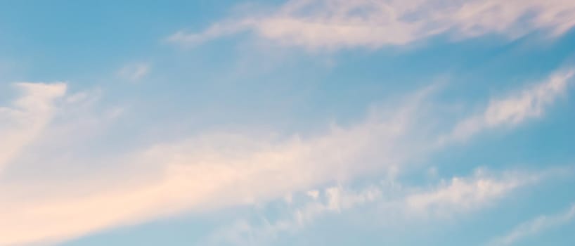 Background of blue sky with white and pink clouds in sunset