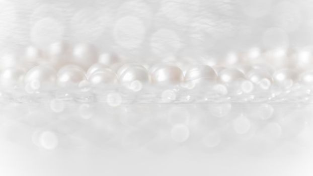 Nature white string of pearls on a sparkling background in soft focus, with highlights