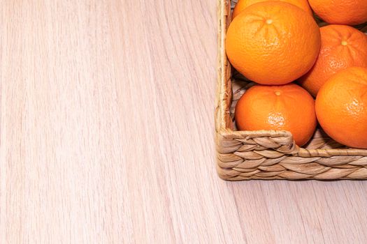 ripe tangerines in a basket on a wooden background. High quality photo