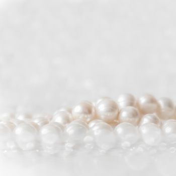 Nature white string of pearls on a sparkling background in soft focus, with highlights