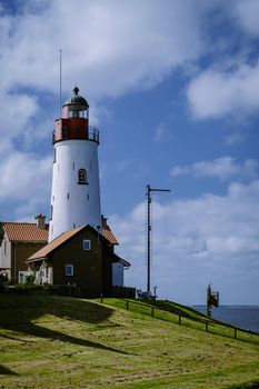 beach with restaurant fishing village Urk lighthouse in Flevoland Netherlands, beautiful Spring day at the former Island of Urk Holland Europe June 2021