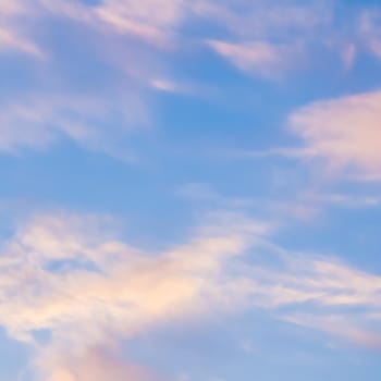 Background of blue sky with white and pink clouds in sunset