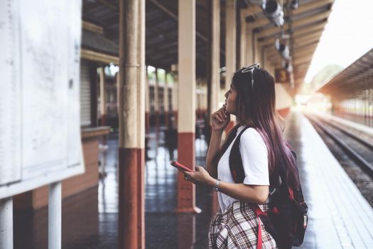 Alone traveler tourist looking at map board with backpack at train station. work and travel lifestyle concept