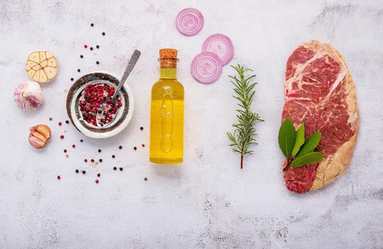 


Raw Striplion Steak set up on white concrete background. Flat Lay of fresh raw beef steak with rosemary and spice on white shabby concrete background top view.
