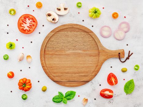 The ingredients for homemade pizza set up on white concrete background.