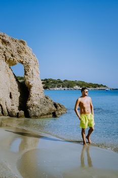 Tropical beach of Voulisma beach, Istron, Crete, Greece Europe, men mid age on the beach during vacation in the summer of Europe