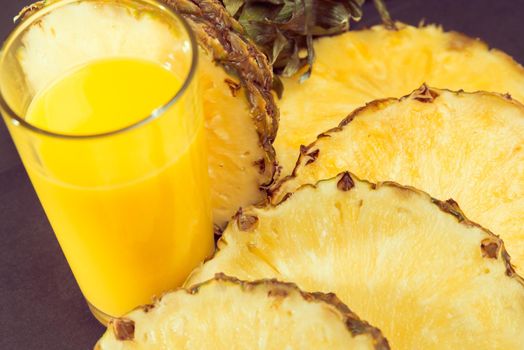 Fresh pineapple juice and pineapple pieces, close-up