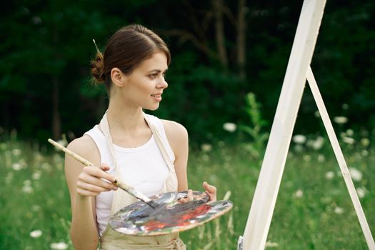 woman outdoors paint a picture landscape hobby creative. High quality photo