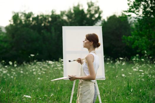 woman artist outdoors easel drawing creative landscape. High quality photo