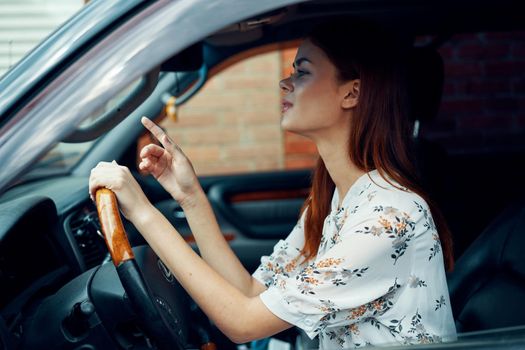 cheerful woman driving a car looks out of the window. High quality photo