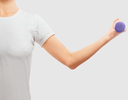 Unrecognizable woman holds a dumbbell, space for text