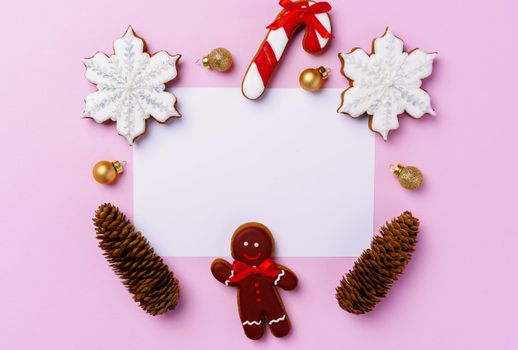Mock up of holiday greeting card with gingerbread cookies on pink background, view from above
