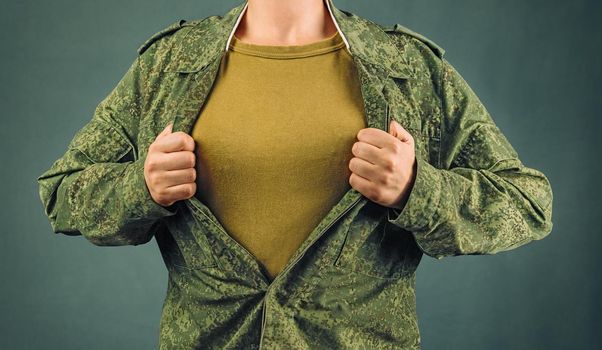 Military woman opens her shirt, space for text, face is not visible