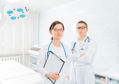 Two young practitioners doctors in a surgical room