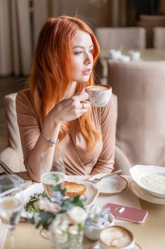 Portrait of a beautiful young elegant blonde woman in the cafe with a glass of champagne