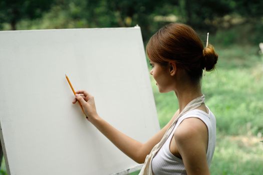 woman outdoors painting a picture creative art landscape. High quality photo