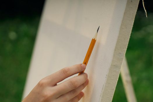 female hand with pencil easel drawing close up. High quality photo