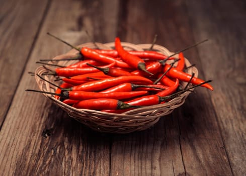 Red chili peppers in the plate on wooden table