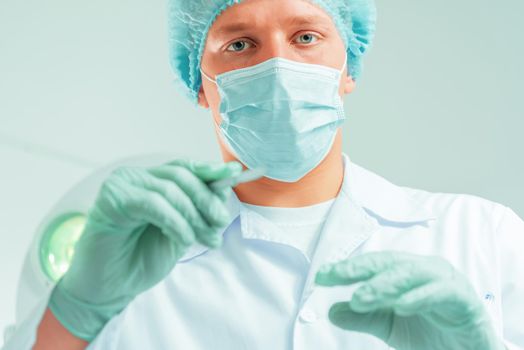 Man doctor surgeon holds a scalpel in an operating room