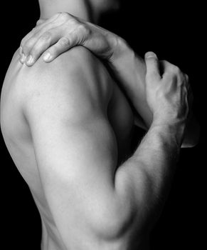 Unrecognizable shirtless man compresses his shoulder, pain in the shoulder