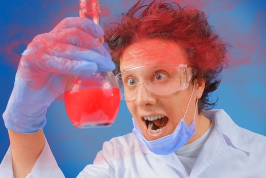 Crazy happy scientist looks at laboratory flask with red liquid