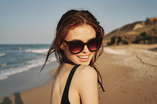 cheerful woman in sunglasses in a swimsuit on the beach sun island. High quality photo