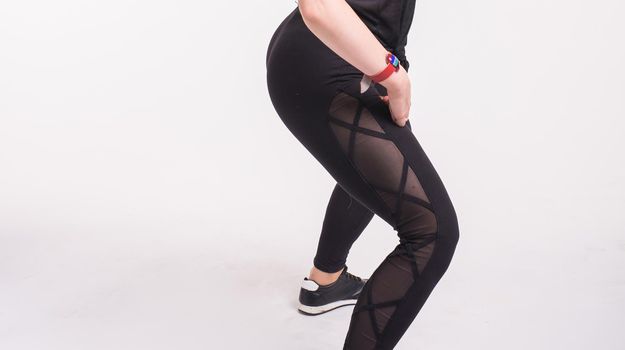 Close-up of girl dancing twerk in the dance class on white background.