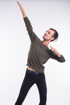 Attractive young man dancing, having fun on white background. Stylish outlook