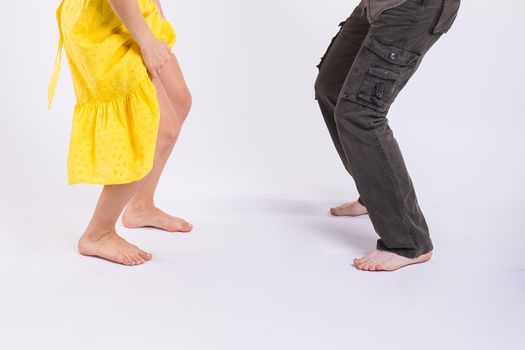 dancing latin music. Bachata, merengue, salsa and kizomba. Close-up of legs elegance pose on white room.