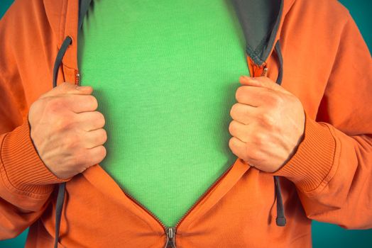 Unrecognizable man opens shirt showing green t-shirt, space for text