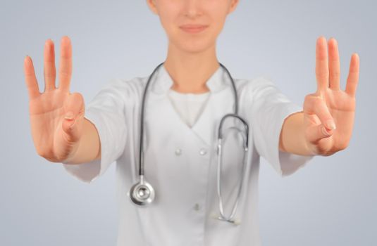 Woman doctor holds something in the air, space for text