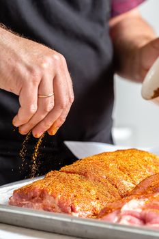 Preparing meat for barbecue grilling. Raw St Louis Style BBQ Ribs covering with salt and spices