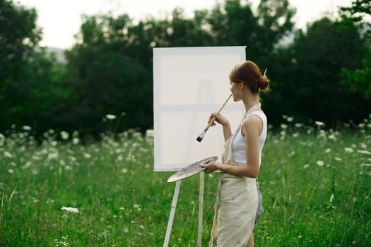 woman artist outdoors easel drawing creative landscape. High quality photo