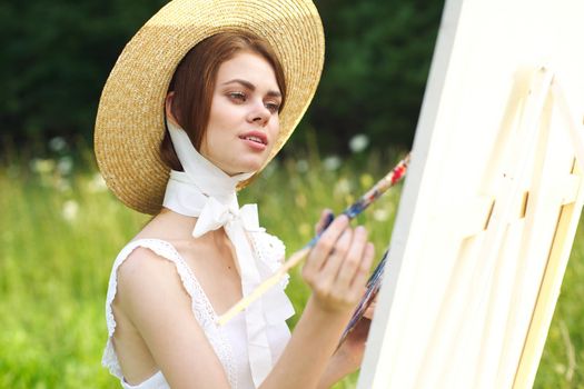 Woman in white dress artist paints on nature palette creative. High quality photo