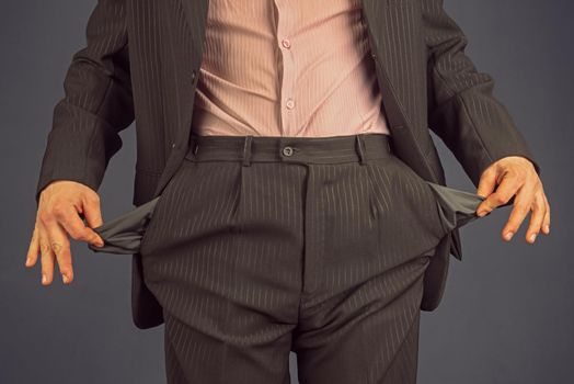 Unrecognizable man in a suit with empty pocket turned inside out