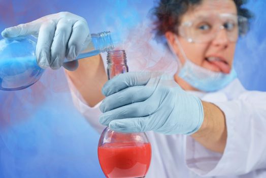 Crazy male scientist is pouring chemical liquid into flask